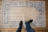 Distressed Oushak rug in ivory and denim blue, showing even knot head wear and foundation.