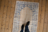 Worn texture of a vintage distressed Oushak rug, faded denim blue on antique ivory.