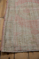 Distressed Oushak rug texture with mostly even wear showing rose and ivory colors.