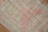 Distressed Oushak runner pile detail showing mostly even wear and muted rose, ivory tones.