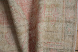 Distressed vintage Oushak rug close-up, showing knot heads, foundation, rose and ivory tones.