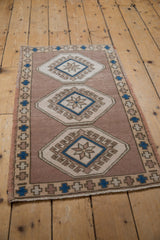 Distressed Oushak rug detail: abrashed field, starburst medallion, and hook and latch motif.