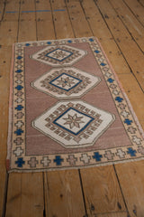 Distressed Oushak rug's hook and latch border, starburst floral medallion, and faded pile.