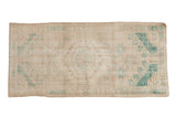 Distressed vintage Turkish Oushak runner with faded diamond medallion, ivory, beige, muted green colors.