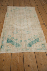 Vintage Oushak corner detail with distressed pile, faded teal motifs, and intact selvage.