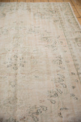 Distressed vintage Oushak carpet pile, with foundation visible through faded blush and green vinery.
