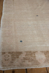 Distressed vintage Oushak rug shows worn beige pile, subtle brown border, and faint foundation.