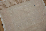 Distressed beige pile texture and secured side selvage of vintage Oushak rug.