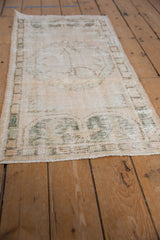 Patinaed texture and border of a vintage Oushak runner, showcasing ivory, beige, and seafoam tones.