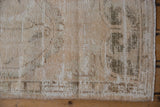Distressed vintage Oushak rug runner with worn pile, visible foundation, and muted green tones.