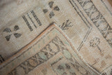 Distressed Oushak rug pile, showing original side cord selvage and foundation.