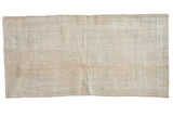 Distressed vintage Oushak runner, faint stepped medallion, muted ivory, beige, sage green.