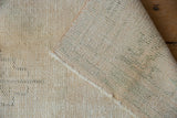 Hand-knotted foundation and textured ivory beige pile of the vintage Distressed Oushak rug.