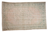 Vintage distressed Oushak carpet, pale beige pink field with ocean green medallion and borders.