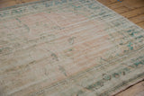 Distressed vintage Oushak carpet with storied texture, featuring pale pink and ocean green hues.