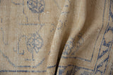 Distressed ivory field with denim blue floral vine details on a vintage Oushak runner.