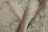Textured distressed Oushak rug pile, with mostly even wear to ivory knot heads.