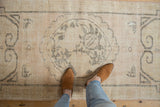 Vintage Distressed Oushak runner's ivory and oxidized silver pattern, worn texture, and feet.