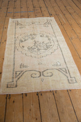 Distressed vintage Oushak runner in time-softened ivory and beige with faded medallion pattern.
