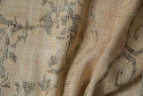 Distressed vintage Oushak rug detail showing worn knot heads, ivory, and time-softened grey pattern.