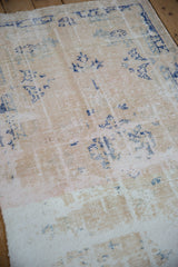 Distressed Oushak rug with faded blue motifs, revealing foundation and worn knot heads.