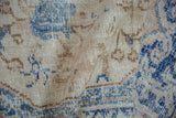 Textured pile of vintage Oushak rug, featuring deep denim blue and ivory vine patterns.