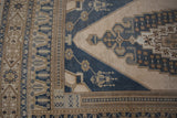 Vintage Distressed Oushak carpet corner: dusty blue, ivory geometric pattern, faint foundation showing.