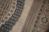 Close-up of distressed vintage Oushak rug showing even wear across blue and beige geometric patterns.