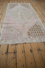 Stepped geometric patterns and soft pink, beige tones on a vintage distressed Turkish Oushak runner.