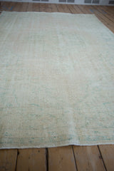 Low pile texture and time-softened wear on a vintage distressed Oushak carpet.
