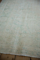 Hand-knotted texture showing the low, worn pile of a distressed vintage Oushak carpet.