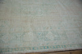 Visible knot heads and low pile texture of a vintage distressed Oushak carpet.