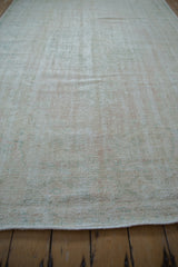 Low-angle view across the soft, distressed texture of a vintage Turkish Oushak carpet.