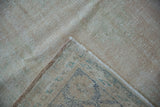 The hand-knotted reverse and soft, low pile of a distressed vintage Oushak carpet corner.