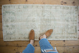 Distressed vintage Oushak rug runner featuring ivory, silver, and dusty olive tones.