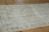 Distressed vintage Oushak runner detail, with visible foundation and muted ivory, dusty olive tones.