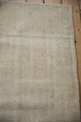 Back of a vintage distressed Oushak rug, showing wear to its ivory foundation and knot heads.