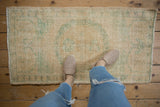 Distressed Oushak runner, low pile texture, soft ivory field with sea foam green patterns.