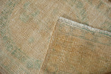 Textured distressed Oushak rug showing worn knot heads, foundation, and ivory fringe.