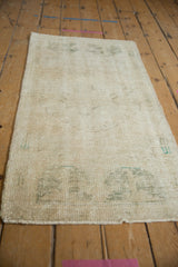 Vintage distressed Oushak runner with ivory field, faded dusty green patterns, and worn pile.