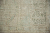 Distressed vintage Oushak rug pile: ivory, pale sea foam green, and wear to knot heads.