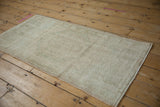 The textural distressed pile of a vintage Oushak rug in muted ivory and pale green.