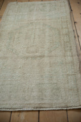 Worn texture of a distressed vintage Oushak rug runner, showing ivory pile.