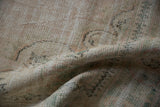 Vintage Oushak carpet, distressed pile revealing soft pale rose and mint patterns.