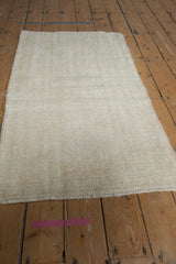 Subtle tone-on-tone ivory and cream texture on a distressed hand-knotted Oushak rug.
