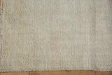 Close-up of distressed vintage Oushak rug's subtle ivory texture and visible foundation.
