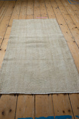 Distressed texture of vintage Oushak rug showing worn ivory and cream tones.