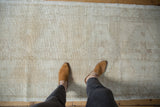 Worn Oushak runner with mostly even wear, foundation visible, subtle ivory geometric patterns.