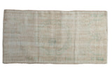 Distressed vintage Oushak runner, ivory field with faded mint green floral medallion.