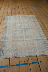 Fringed end and distressed texture of a vintage Oushak rug with faded denim blue accents.